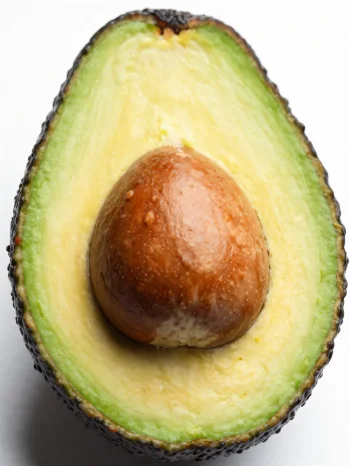 Avocado proaspăt tăiat, cu interior verde cremos, pe o suprafață de lemn