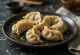 Jiaozi chinezesc cu vită fiert, servit pe farfurie de porțelan, tăiat, umplutura vizibilă