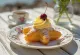 Zeppole di San Giuseppe, umplute cu cremă de vanilie și cireșe, pudrate cu zahăr