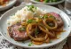 Bistec Encebollado, vită cu ceapă pe farfurie