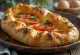 Khachapuri cu roșii, turte cu brânză proaspete, aurii, cu felii de roșii