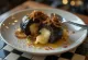 Black pudding umplut cu brânză, servit cu ceapă caramelizată și pătrunjel proaspăt